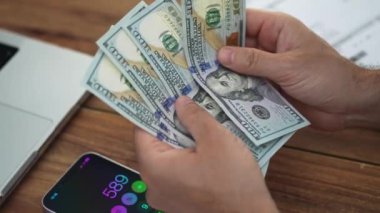 İşadamı her banknota dikkat eden bir tomar dolar sayıyor. Erkek muhasebeci nakit parayı hesaplıyor. Döviz kurlarını yavaş çekimde takip ediyor.