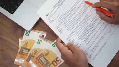 Ofis çalışanı, W-4 formunun incelenmesine özel satırları belirterek dikkatle dikkat eder. İnsan, tüm detayların vergi uyum standartlarını yavaş çekimde karşılamasını sağlar.