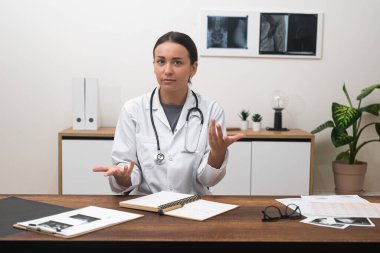 Çevrimiçi Sağlık Sağlayıcı: kadın doktor, hasta internetteki teletıp dünyası ile iletişim kurarken kameraya bakıyor. 