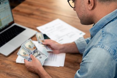 Erkek kiracı, işyerindeki faturaların üzerindeki dolar banknotlarını sayar, konsantre adam, iş yerindeki düzenli ev giderleri için nakit hazırlar, finansal evraklar