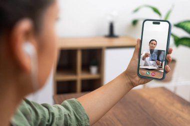 Hastanın uzman tıbbi görüşünü, telefondaki röntgenleri inceleyen bir doktorla görüntülü görüşme yoluyla alıyor..