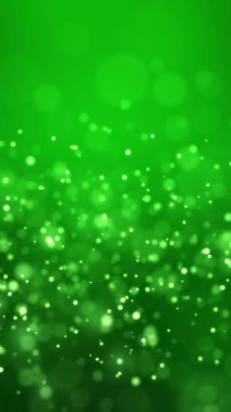 Altın ışık parçacıklarının yeşil zemin üzerinde bokeh video animasyonu - soyut parçacıklar arka plan - dikey video