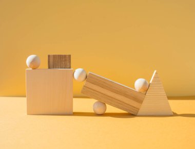 Parlak sarı arkaplanda tahta nesnelerle kompleks geometrik bileşim