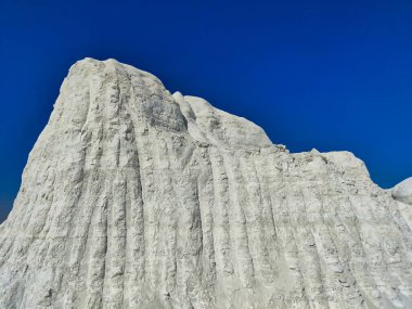 Picture of a big snow covered mountain with blue sky shot during sunlight. White snowy mountain hills, nature, landscape in winter