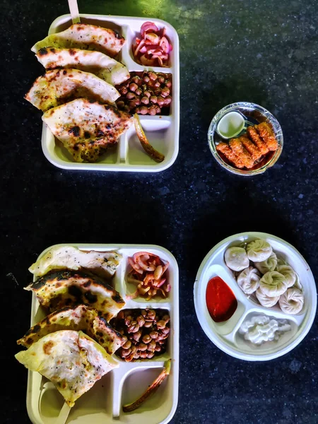 Picture of a combo meal serving Chinese momos, Punjabi Chole Kulche and Paneer Pakoda. Food and Beverages industry India