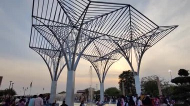 Jaipur, India Circa 2023: Mansarovar 'daki City Park' taki bir anıtın ve kalabalığın hızlandırılmış görüntüleri. Akşamları, mavi gökyüzüne karşı gün batımında çekiliyor.