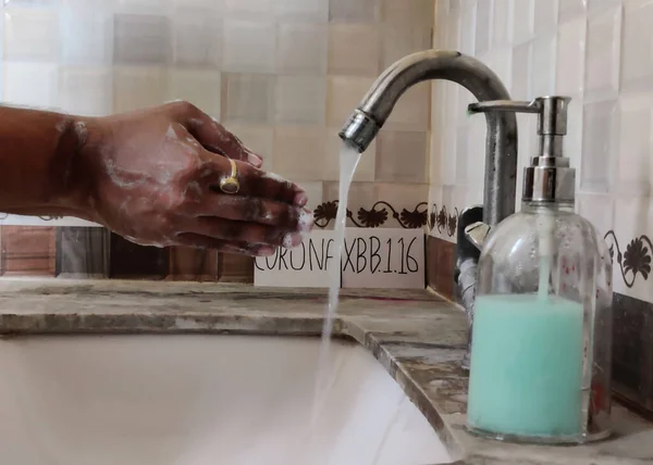 Picture of a person washing hands with soap with a placard having Corona and XBB1.16 written on it in background. Hand washing is important for protection from Corona virus. Corona XBB1.16 new Strain of corona virus.