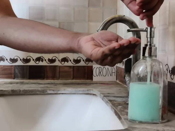Picture of a person washing hands with soap with a placard having Corona written on it in background. Hand washing is important for protection from Corona virus. Corona XBB1.16 new Strain of corona virus