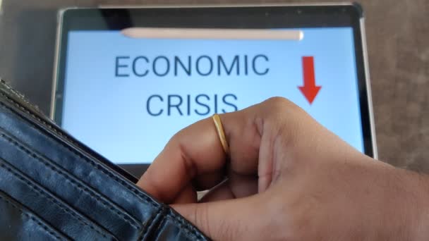 財布からお金を出している人の映像 下向きの矢印を持つ経済危機が背景に書かれています 映像は経済の秋を描いた — ストック動画