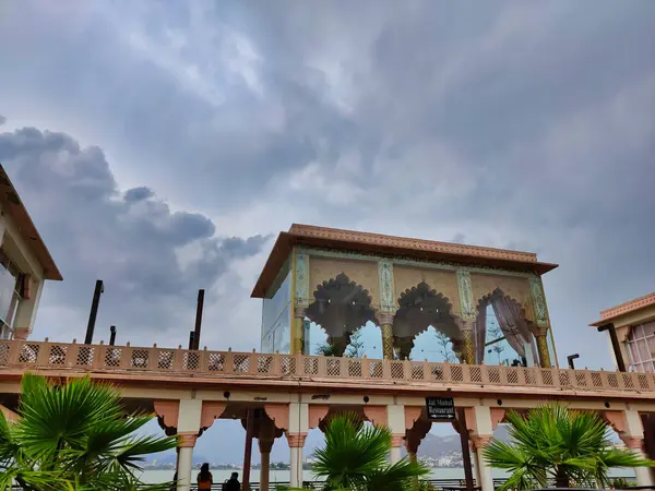 Ajmer, India Circa 2023: Ana Sagar Gölü 'ndeki Göl Noktası Görünümü. Gökyüzünde gri bulutlar ve arka planda tepeler olan su gövdesi yağmurlu bir günde çekim yapar.