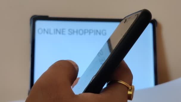 用带有Online Shopping的手机在模糊背景的标语牌上工作的人的形象 — 图库视频影像