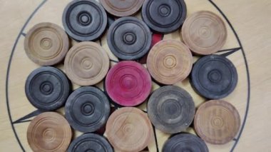 Tahtanın ortasında düzenlenmiş carrom sikkeleri olan bir carrom tahtası görüntüsü