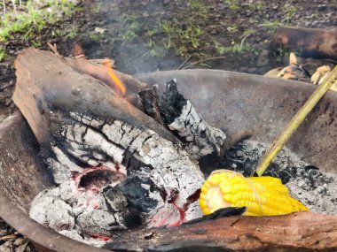 Haşlanmış mısırın hazırlanması, gün ışığında yapılan pazar çekimlerinde yumuşaklığı ve yemeğe hazır hale getirir.