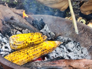 Haşlanmış mısırın hazırlanması, gün ışığında yapılan pazar çekimlerinde yumuşaklığı ve yemeğe hazır hale getirir.