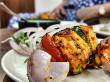 Lokantada servis edilen Paneer Tikka çanağının yakından çekimi. Otelde yiyecek ve içecekler.