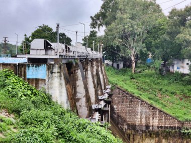 Banswara, Rajasthan, Hindistan 9 Ağustos 2024: Güzel bir günbatımına karşı bir barajın kapılarının resmi. Arkaplanda yeşil ağaçlar