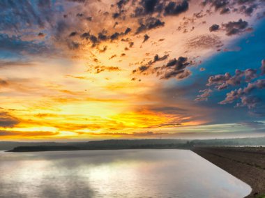 Bir gölün manzarası, tepeler, güzel bir günbatımına karşı çekilen ağaçlar. Banswara 'daki Mahi Barajı' ndan manzara