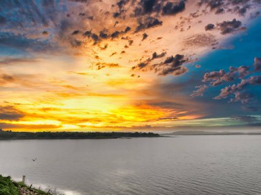 Bir gölün manzarası, tepeler, güzel bir günbatımına karşı çekilen ağaçlar. Banswara 'daki Mahi Barajı' ndan manzara
