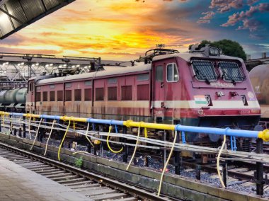 Ratlam, Madhya Pradesh, Hindistan 9 Ağustos 2024: Güzel bir gün batımına karşı bir istasyonda çekilen tren vagonlarının resmi