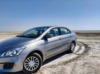 Sambhar, Rajasthan, Hindistan 24 Mart 2025: Sambhar Gölü 'nde gün batımında çekilen bir sedan araba resmi. Sambhar Gölü 'nde Maruti Suzuki Ciaz.