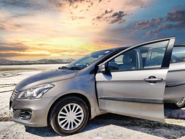 Sambhar, Rajasthan, Hindistan 24 Mart 2025: Sambhar Gölü 'nde gün batımında çekilen bir sedan araba resmi. Sambhar Gölü 'nde Maruti Suzuki Ciaz.