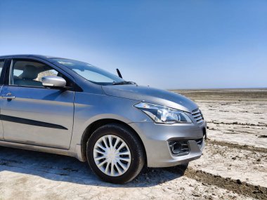 Sambhar, Rajasthan, Hindistan 24 Mart 2025: Sambhar Gölü 'nde gün batımında çekilen bir sedan araba resmi. Sambhar Gölü 'nde Maruti Suzuki Ciaz.