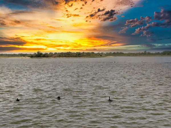 Bulutlu gökyüzü ile gölün üzerinde güzel bir günbatımı resmi. Doğa bileşimi.