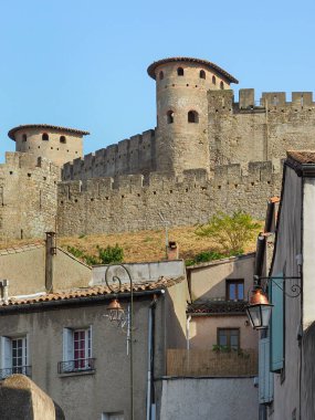 Savunma duvarları ve kuleleri olan Cit de Carcassonne. Ünlü ortaçağ şehir manzarası, Hisar ya da Carcassonne Kalesi. Arka planda mavi gökyüzü. Occitanie bölgesi, Fransa.