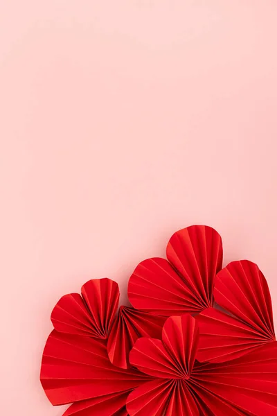 Passion love Valentine day background with red paper hearts of asian fans in modern fashion style on cute soft light pastel pink backdrop, border, copy space, top view, vertical.