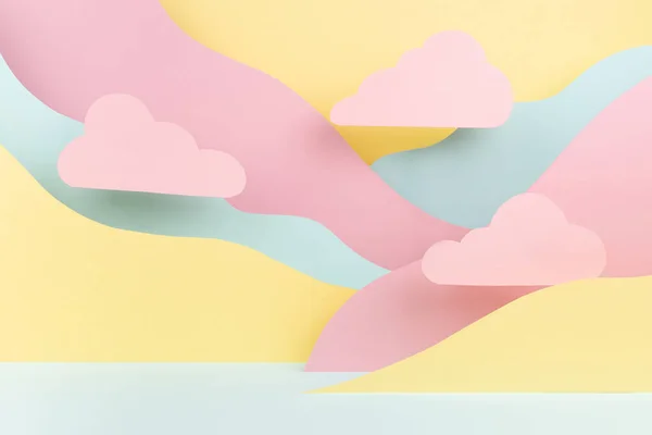 Bright abstract stage mockup - paper landscape with pastel pink clouds, mountains pink, yellow, mint color in modern vapor wave style. Showroom template for advertising, design, presentation cosmetic.
