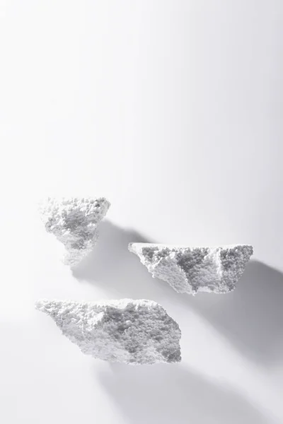 Art white podiums of bubble styrofoam as stones mockup soar in heaven for presentation, showing cosmetic products, goods in bright light, shadow, vertical, copy space. Template scene in minimal style.