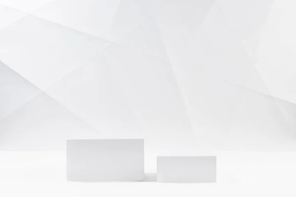 White modern stage with two square podiums in hard light mockup in white interior with lines and angles of graphic geometric minimal style for presentation cosmetic products, goods, branding, design.