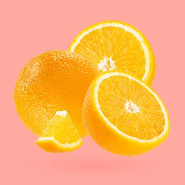 ジューシーなオレンジのクローズアップは アートの構成として飛ぶ パステルピンクのバックグラウンドに全体 半分とピースのフルーツ デザイン ラベル製品のための夏のフルーツ — ストック写真