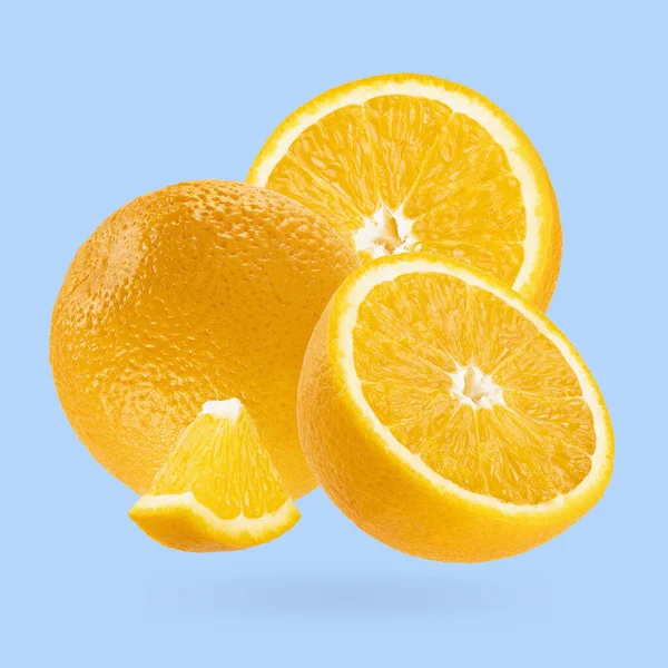 ジューシーなオレンジのクローズアップは アートの構成として飛ぶ パステルブルーのバックグラウンドに全体 半分とピースのフルーツ デザイン ラベル製品のための夏のフルーツ — ストック写真