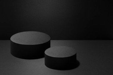 Abstract two black round podiums for cosmetic products with light beams, mockup on black background. Scene for presentation products, goods, advertising, design, display, showing in concert style. clipart