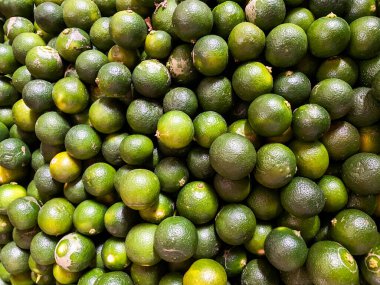 Taze yeşil limonların arka plan olarak en üst görünümü. 