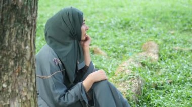 ,Parkta oturan düşünceli Müslüman kadınlar. .