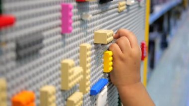 çocuk eli renkli yapı bloğuyla oynuyor .