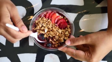 women holding a bowl of breakfast cereal on table .