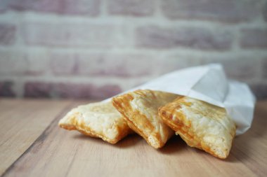 Masadaki kağıt pakette elmalı turta ,