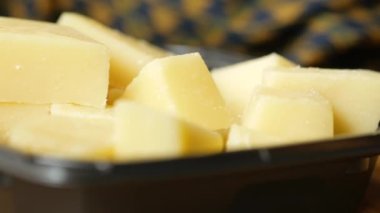 close up of cube shape fresh cheese on in a bowl .