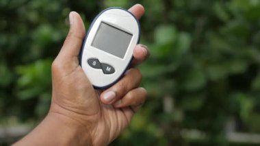 Glikoz ölçer tutan adam. ,