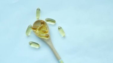 Beyaz arka planda kaşıkta balık yağı takviyesi .