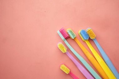  Pembe arka plan görünümünde renkli diş fırçaları ,