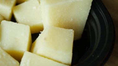 close up of cube shape fresh cheese on in a bowl .