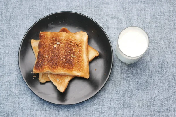 Φρυγανισμένο Ψωμί Και Ένα Ποτήρι Γάλα Στο Τραπέζι — Φωτογραφία Αρχείου