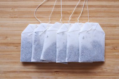 Çay poşetleri ve sarı renkli bardak masanın üstünde. .