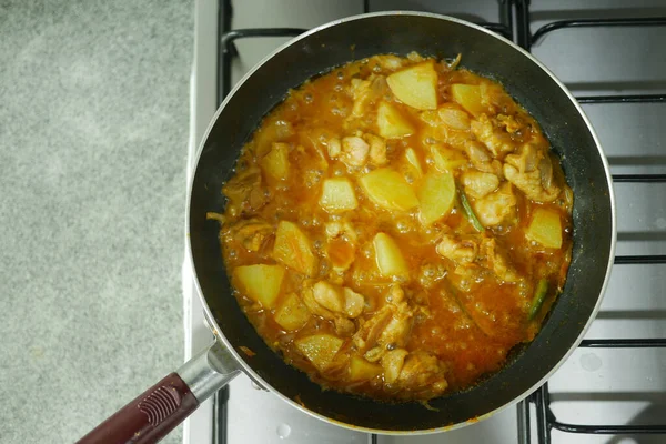 cooking chicken curry in a cooking pan ,