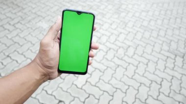 Açık havada akıllı telefon kullanan genç bir adamın dikiz görüntüsü .