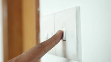 Işık düğmesini açan bir parmak